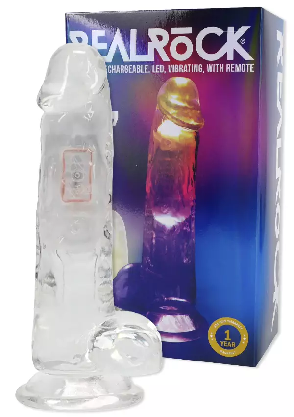 Kirkas dildo muistuttaa aitoa penistä. Taustalla pakkaus, jossa dildossa palaa led valot - Vibraattorit - 8714273059611 - 1